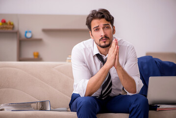 Fototapeta premium Young male employee working from home during pandemic