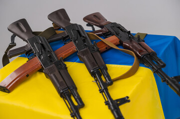 Three loaded Kalashnikov 74 assault rifles on the blue and yellow flag of Ukraine