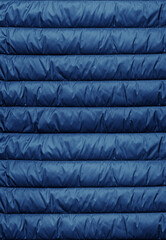 Quilted pattern. Texture of puffer, padded, down jacket. Background of urban winter outfit.