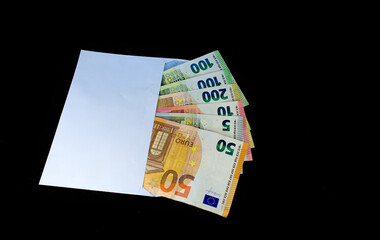Euro in a white envelope on a black background. The concept of the 