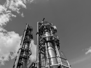 The main distillation column of oil and petroleum products in close-up with copyspace. Black and white photo