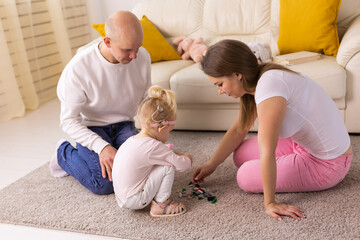 Happy child girl with cochlear implant having fun with her family - hearing aid for deaf and...