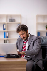 Obraz premium Young male employee unhappy with excessive work in the office