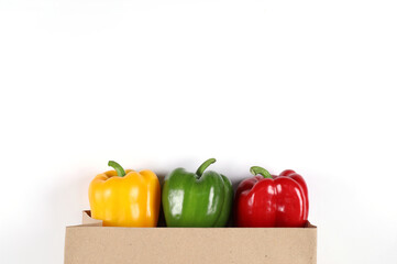 Fresh green sweet pepper Yellow sweet pepper and red sweet pepper in a paper bag on a white background. Green Red Yellow bell pepper. top view with copy space