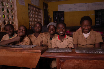 Group of pupils sitting at school desks with their blackboards happy laughing