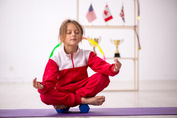Young little girl doing sport exercises at home