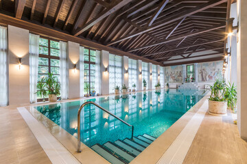 Spacious room of a private house with large windows and a swimming pool.