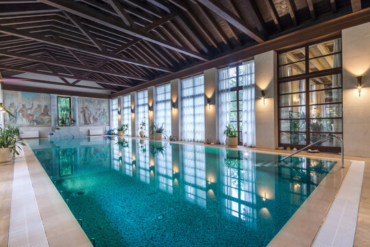 Stylish interior of a country house with a large azure swimming pool.