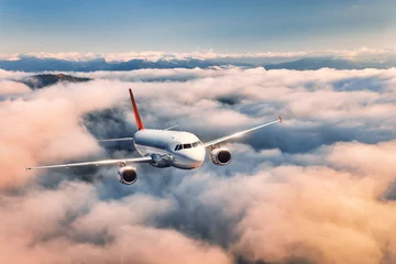 Fototapeten Airplane is flying above the clouds at sunset in summer. Landscape with passenger airplane, beautiful clouds,  blue sky. Aircraft is taking off. Business travel. Commercial plane. Aerial view © den-belitsky