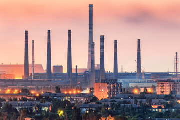 Steel plant at sunset in Mariupol, Ukraine before war. Steel factory with smokestacks. Steel works, iron works. Heavy industry. Industrial landscape with metallurgical combine, smokes, lights