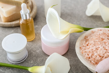 Obraz na płótnie Canvas Cosmetic products, sea salt and calla lilies on table, closeup