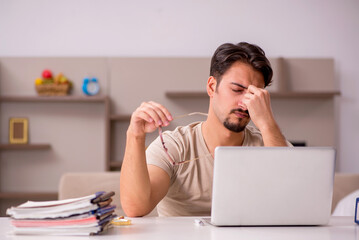 Young male employee working from house