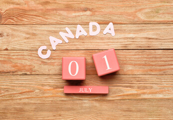 Cube calendar with date JULY 1 and word CANADA on wooden background. Happy Canada Day