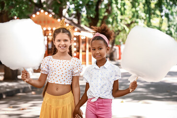 Cute little girls with cotton candy outdoors