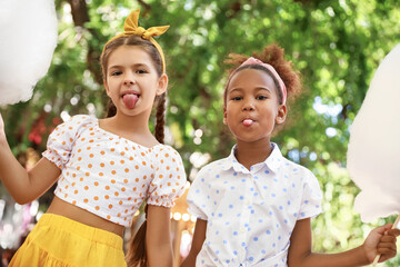 Cute little girls with cotton candy outdoors