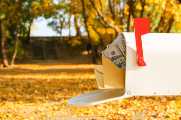 Mailbox with money in autumn park