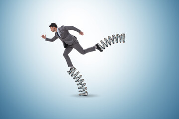 Businessman jumping high on springs