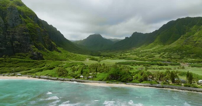 Flying towards famous Koolau Mountains and road by the ocean, Oahu Island, Hawaii
