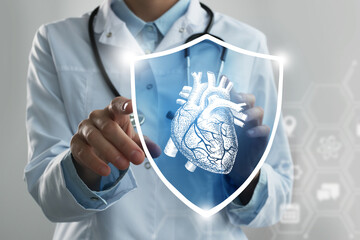 Unrecognizable female doctor holding shield and graphic virtual visualization of  Heart organ in...