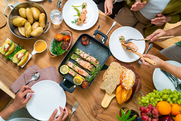 Group of Asian people friends enjoy dinner party eating food and drinking wine on the table with...