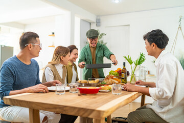 Group of Asian people friends enjoy dinner party eating food and drinking wine on the table with talking together at home. Happy man and woman reunion dinner meeting celebration on holiday vacation