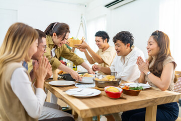 Group of Asian people friends enjoy dinner party eating food and drinking wine on the table with...