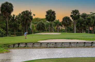 a golfer putting at sunset