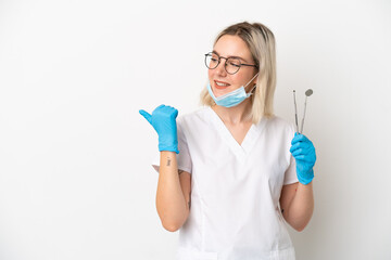 Dentist caucasian woman holding tools isolated on white background pointing to the side to present a product