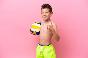 Little caucasian boy playing volleyball isolated on pink background with thumbs up because something good has happened