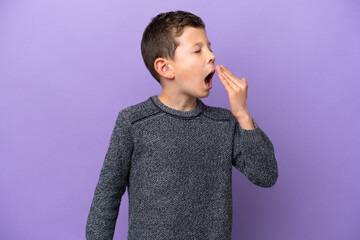 Little boy isolated on purple background yawning and covering wide open mouth with hand