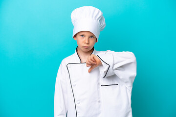 Little chef boy isolated on blue background showing thumb down with negative expression