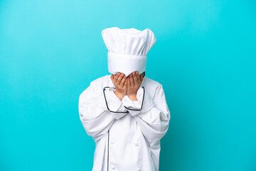 Little chef boy isolated on blue background with tired and sick expression