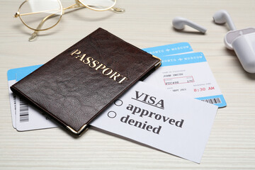 Passport, tickets, earphones and glasses on white wooden table, closeup. Visa receiving