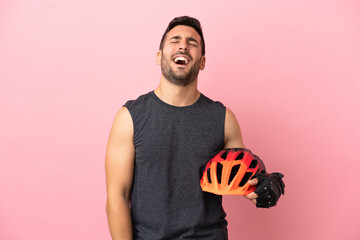 Young cyclist man isolated on pink background laughing - obrazy, fototapety, plakaty
