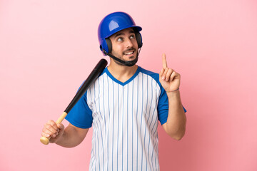 Baseball player with helmet and bat isolated on pink background pointing up a great idea