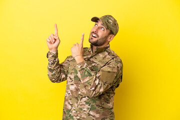 Military man isolated on yellow background pointing with the index finger a great idea