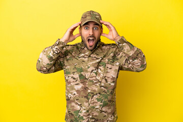 Military man isolated on yellow background with surprise expression