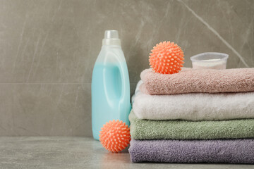 Fototapeta Dryer balls, detergents and stacked clean towels on grey marble table. Space for text obraz