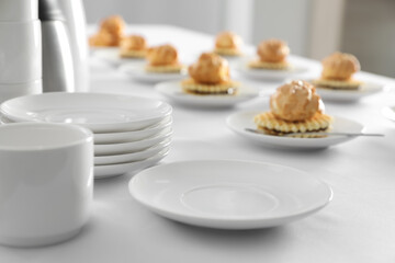 Many delicious waffles with cream served on white table for coffee break