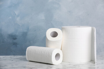 Rolls of paper towels on white marble table. Space for text