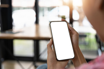 Mockup image of a beautiful woman holding and showing a mobile phone with blank white screen.