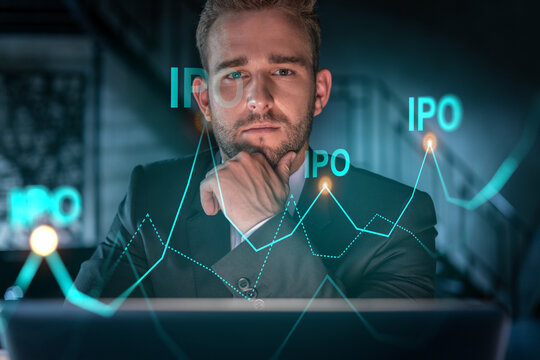 Portrait of handsome businessman in formal suit thinking how to optimize IPO strategy. Financial chart hologram over modern office background. Go public concept. Hand on chin.