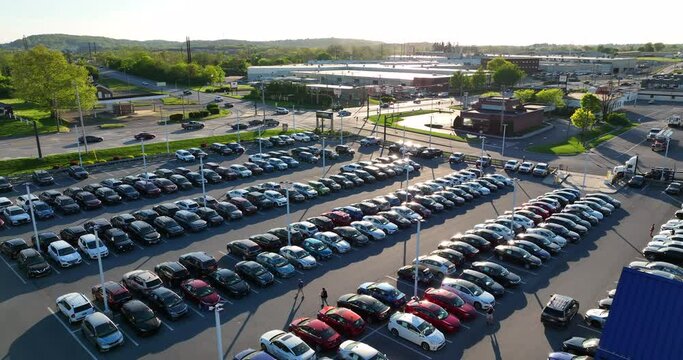 CarMax dealership parking lot. Used cars for sale. Aerial view of full parking lot during spring sunset.