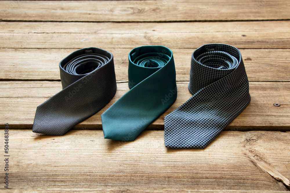 Wall mural three blue ties lie on a wooden table, different men's ties close up