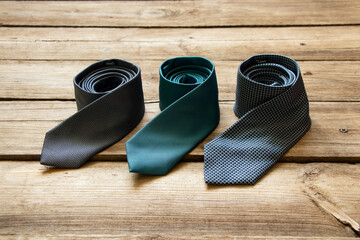 Three blue ties lie on a wooden table, different men's ties close up