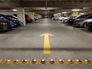 Subterranean parking with a traffic sign of yellow arrow indicating the direction of the road