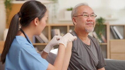 A kind female nurse and a senior male patient apply a plastic bandage after vaccination or medicine on upper arm. Caring for after retirement physical health therapist. old man home care concept