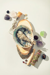 Healing crystals, palo santo, white sage bundle on abalone sea shell, dry healing herbs on white...