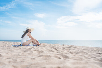 Fototapeta na wymiar Vacation on the beach, Young woman relaxing on the beach in summer