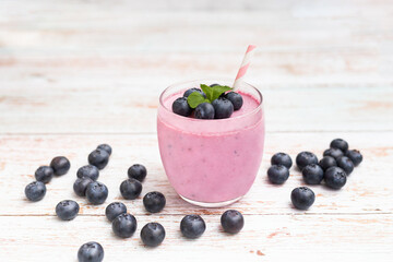 Fototapeta na wymiar Healthy breakfast of smoothie, dessert, yogurt or milkshake with fresh blueberry on whtite wooden table.